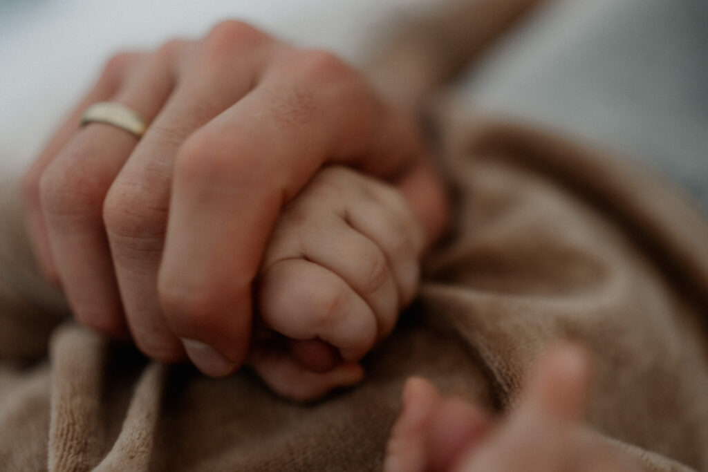 Familienshooting. Nahaufnahme Hände von Papa und Baby.