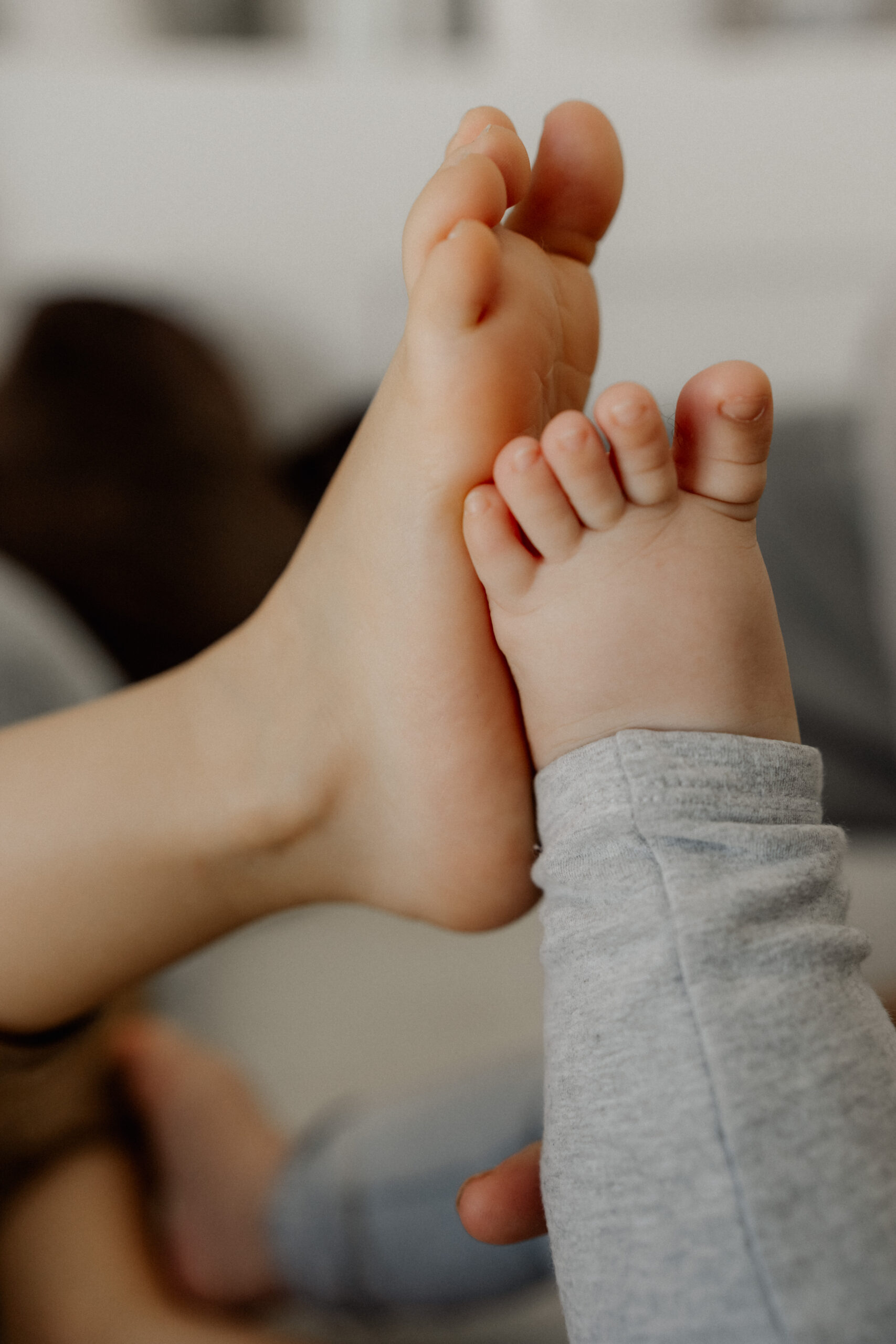 Familienshooting Eppingen Homestory. Großer Bruder und Baby vergleichen die Füße.