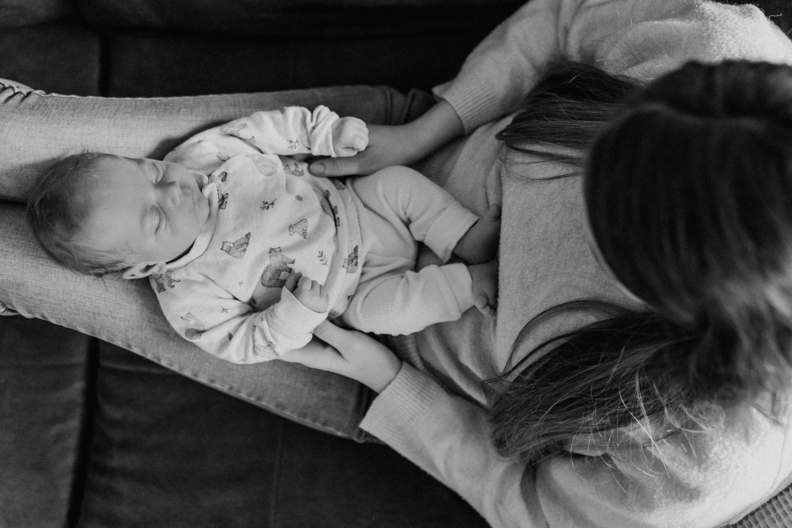 Newbornshooting Eppingen Homestory. Das Baby liegt bei der Mama auf den Beinen.