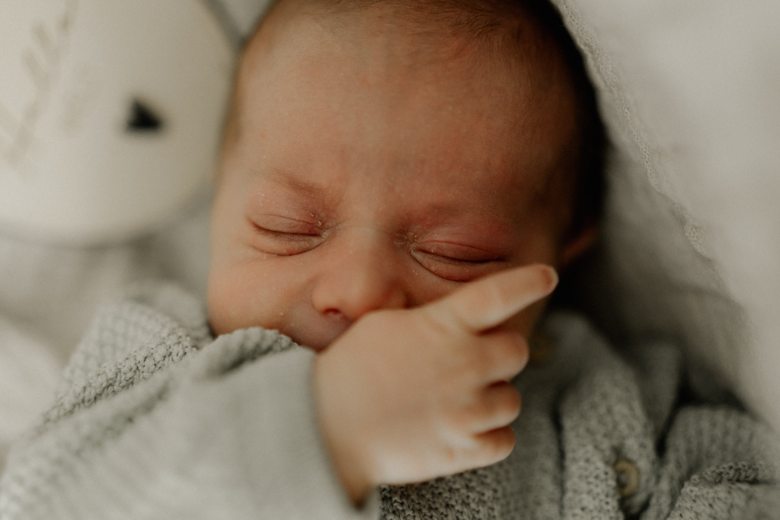 Newbornshooting Eppingen Homestory. Neugeborenes nuckelt am Daumen.