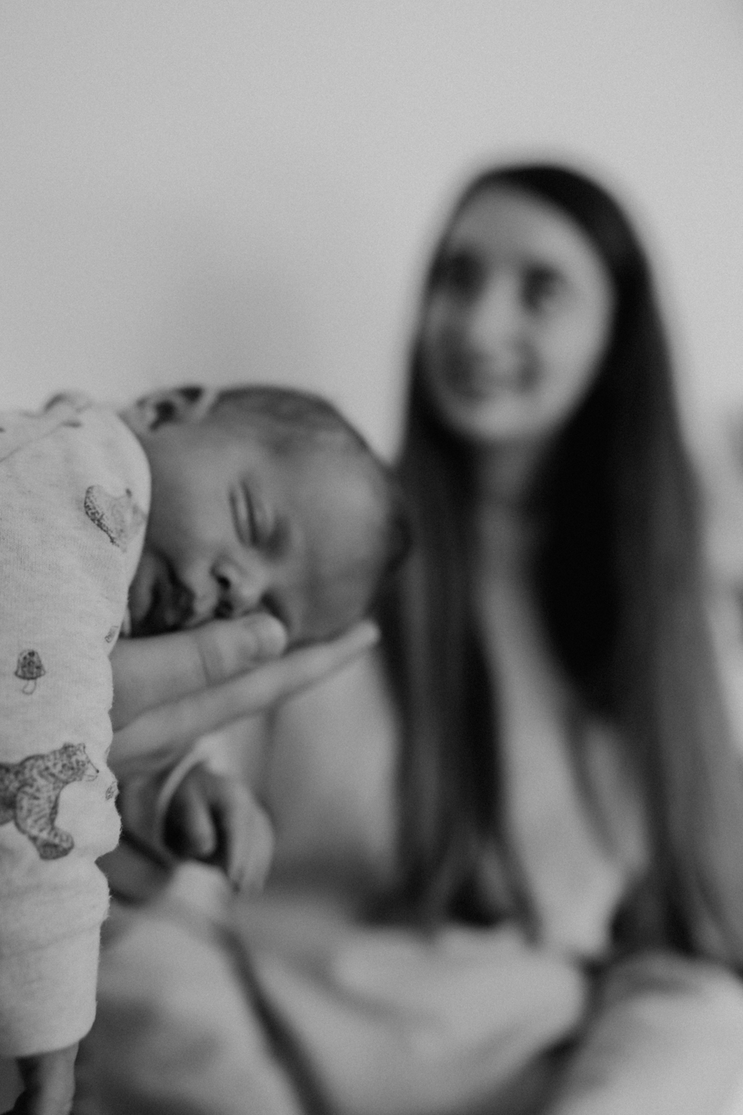 Newbornshooting Eppingen Homestory. Papa hält das Neugeborene im Fliegergriff auf dem Unterarm.