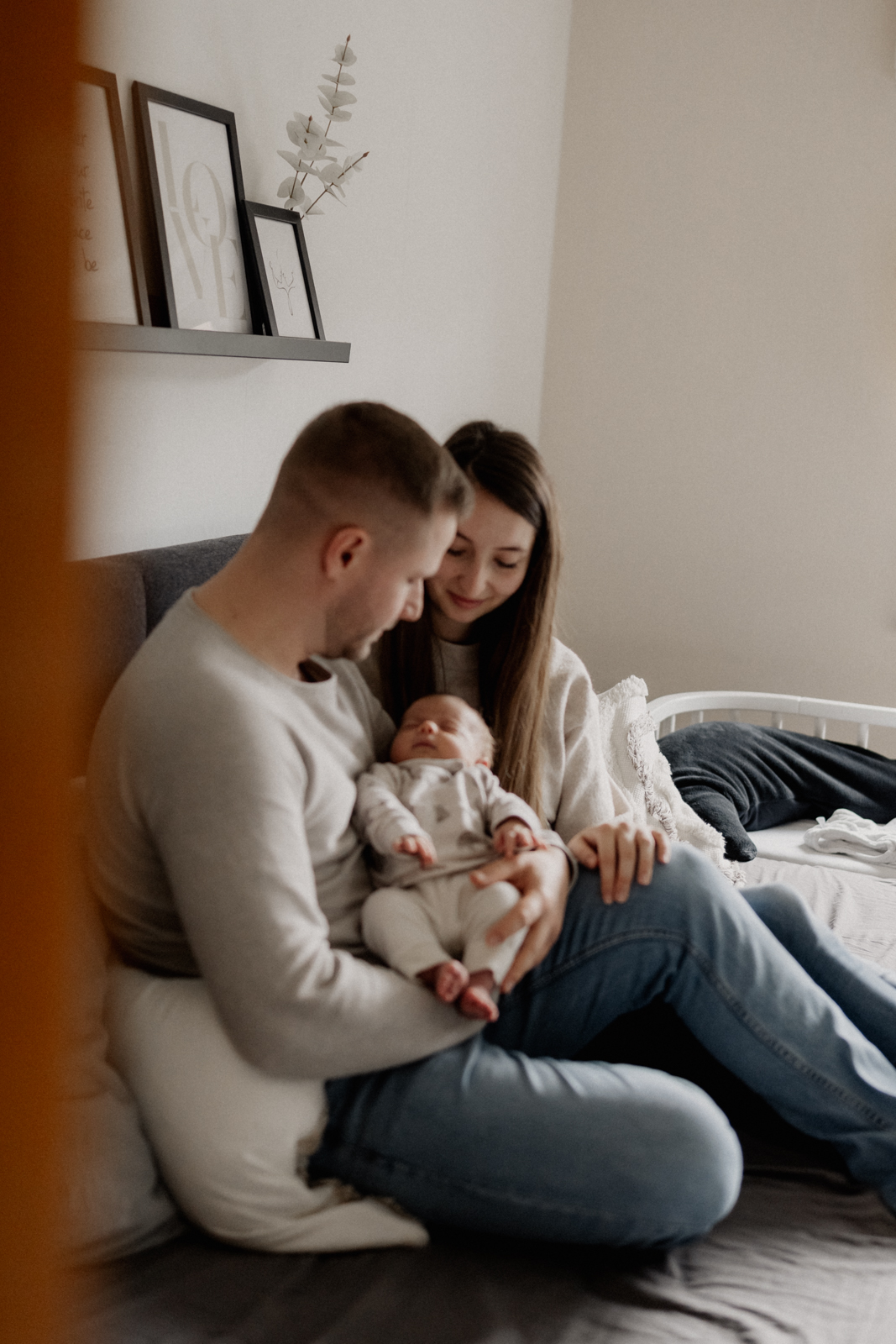 Newbornshooting Eppingen Homestory. Papa hält das Neugeborene schlafend im Arm.