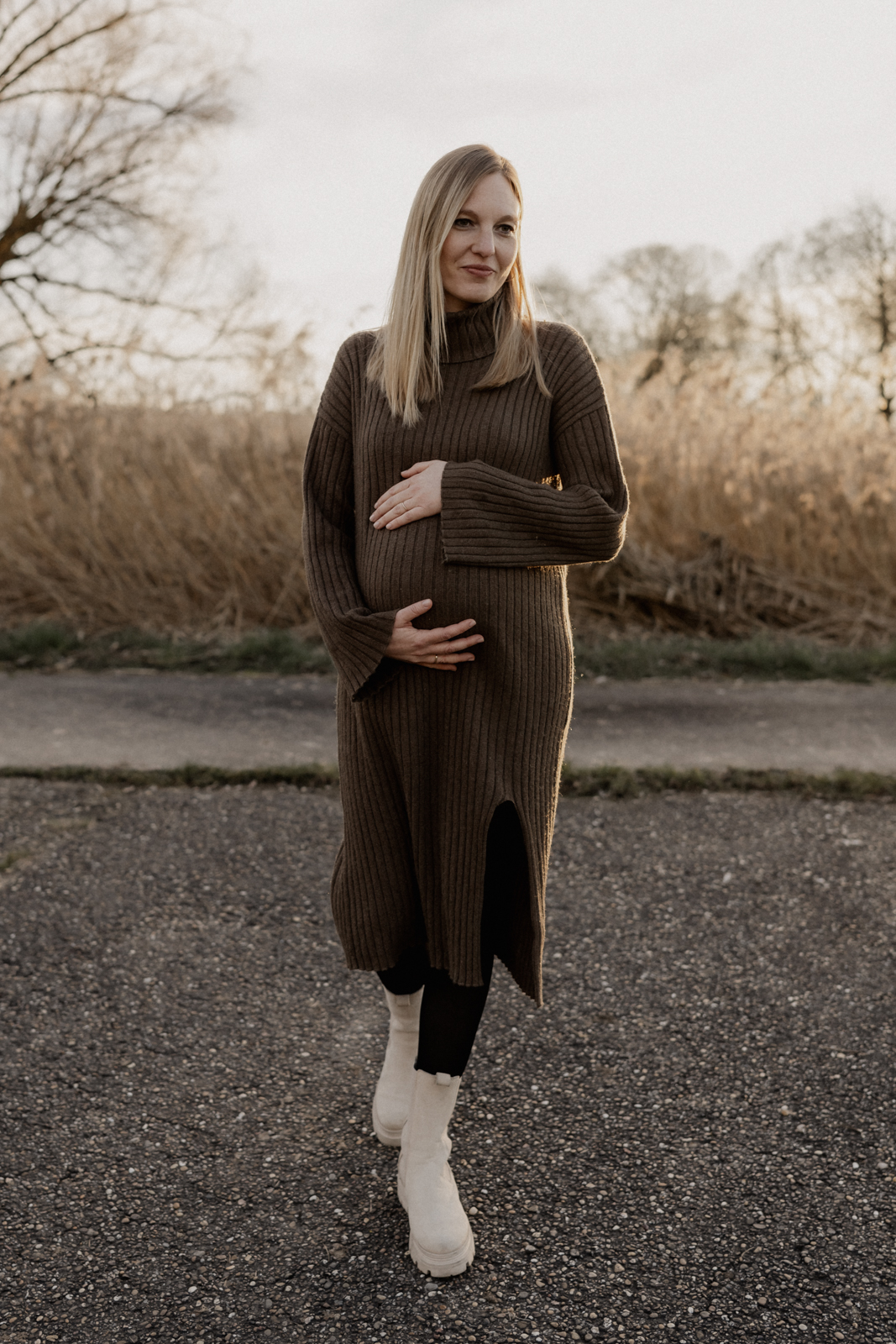 Schwangere Frau streicht über ihren wunderschönen Babybauch.