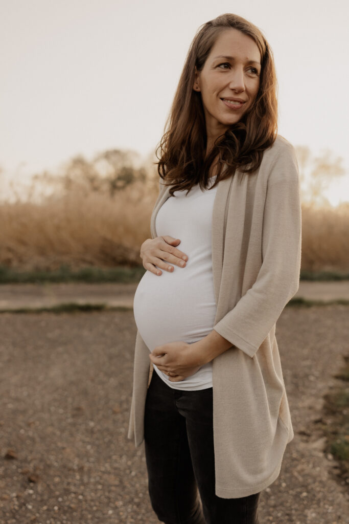 Babybauchshooting Eppingen. Mama streichelt über ihren Babybauch.